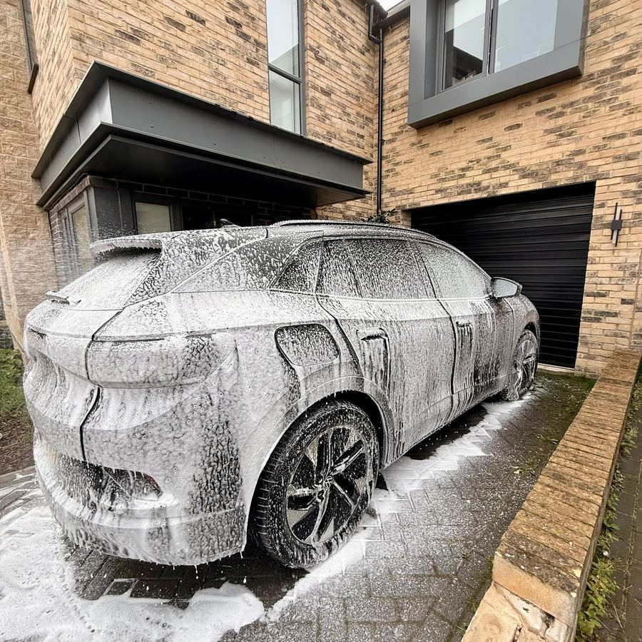 A Volkswagen ID.4 covered head to toe in snow foam on a Harrogate driveway